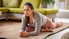 Woman stretching on a carpet in a domestic setting