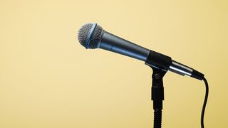 Shure SM58 mounted to a microphone stand on a yellow background