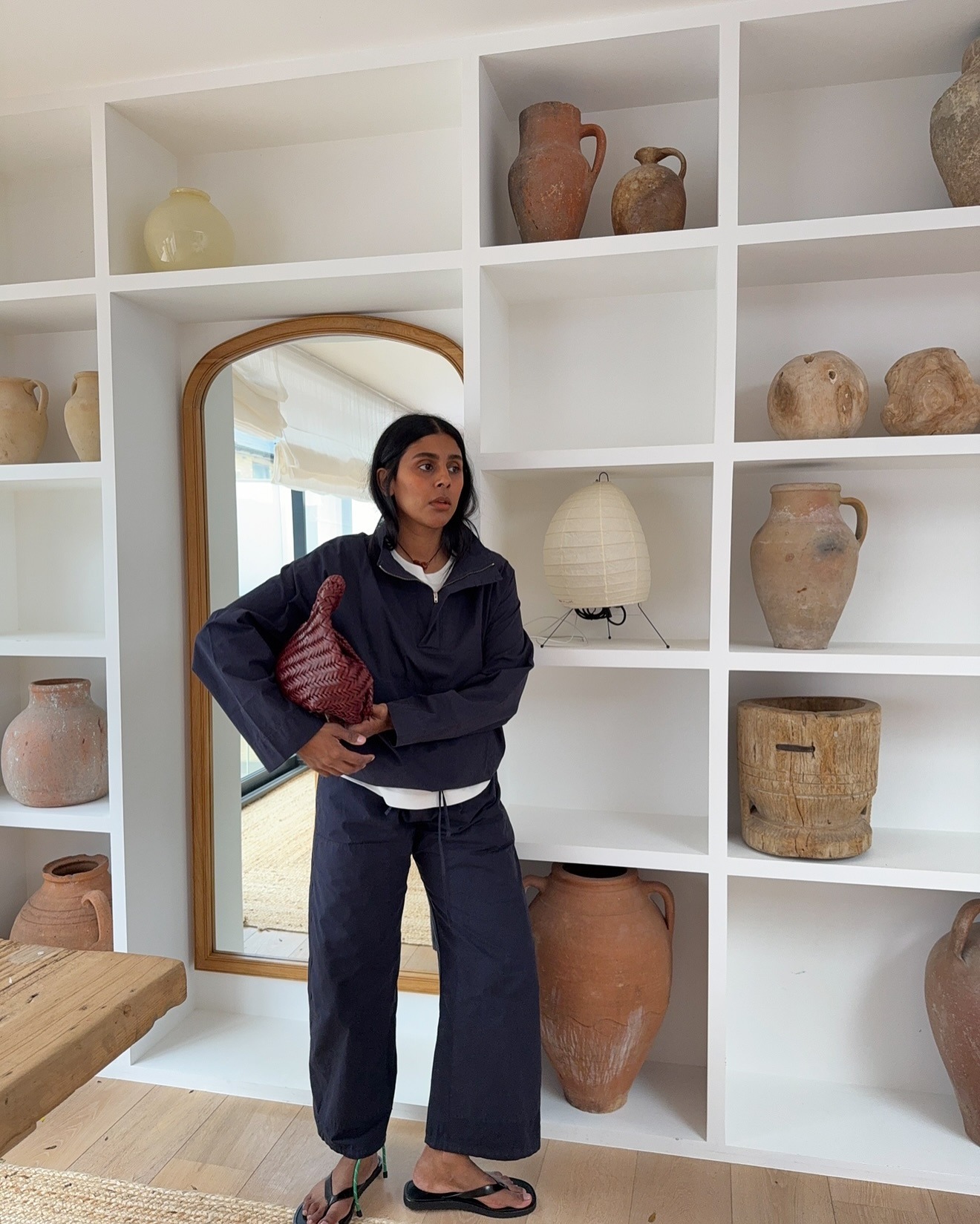 Monikh wears a navy jacket, white tee, navy kyoto pants, and flip-flops.