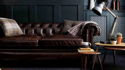 dark living room with leather sofa and dark floor