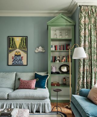 Blue living room with pale green shelving and patterned sofa