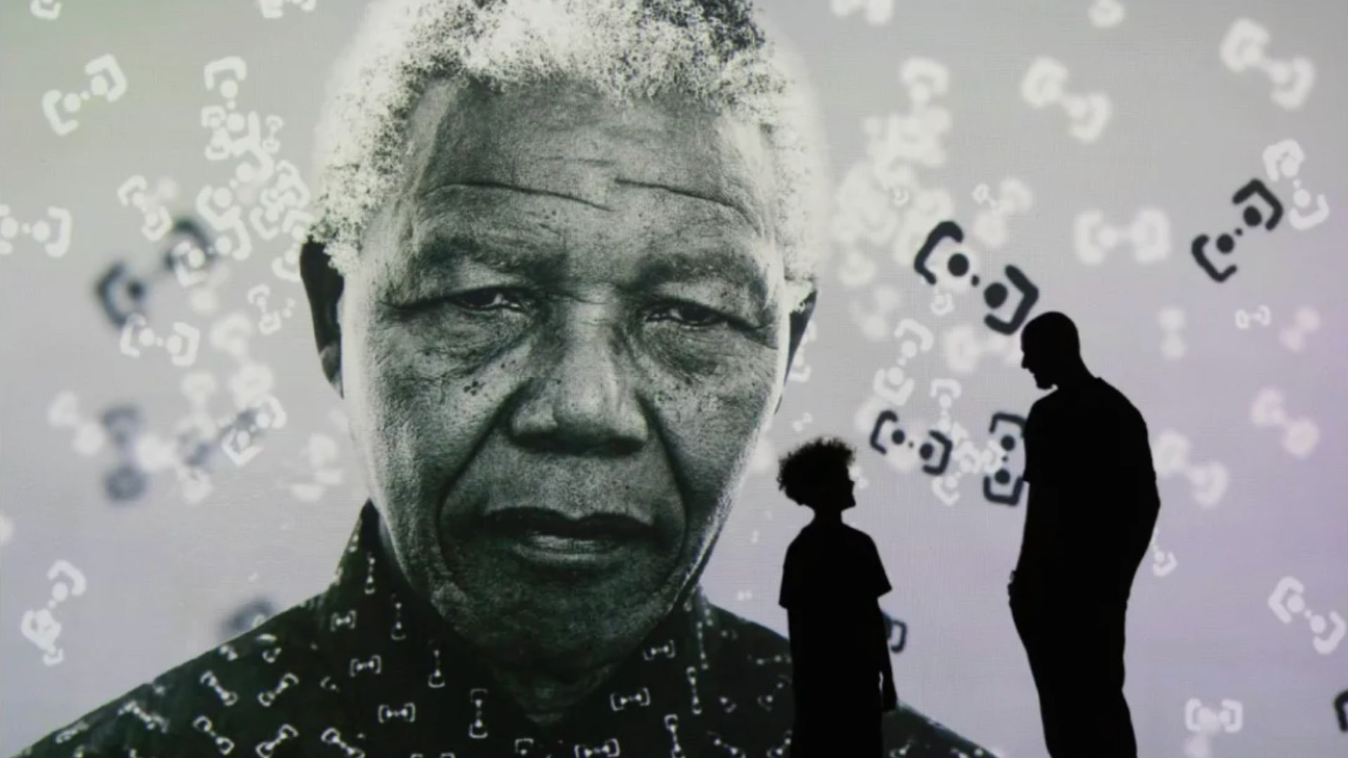 an image projection of Nelson Mandela in the gallery exhibition with a father and son looking at the portrait