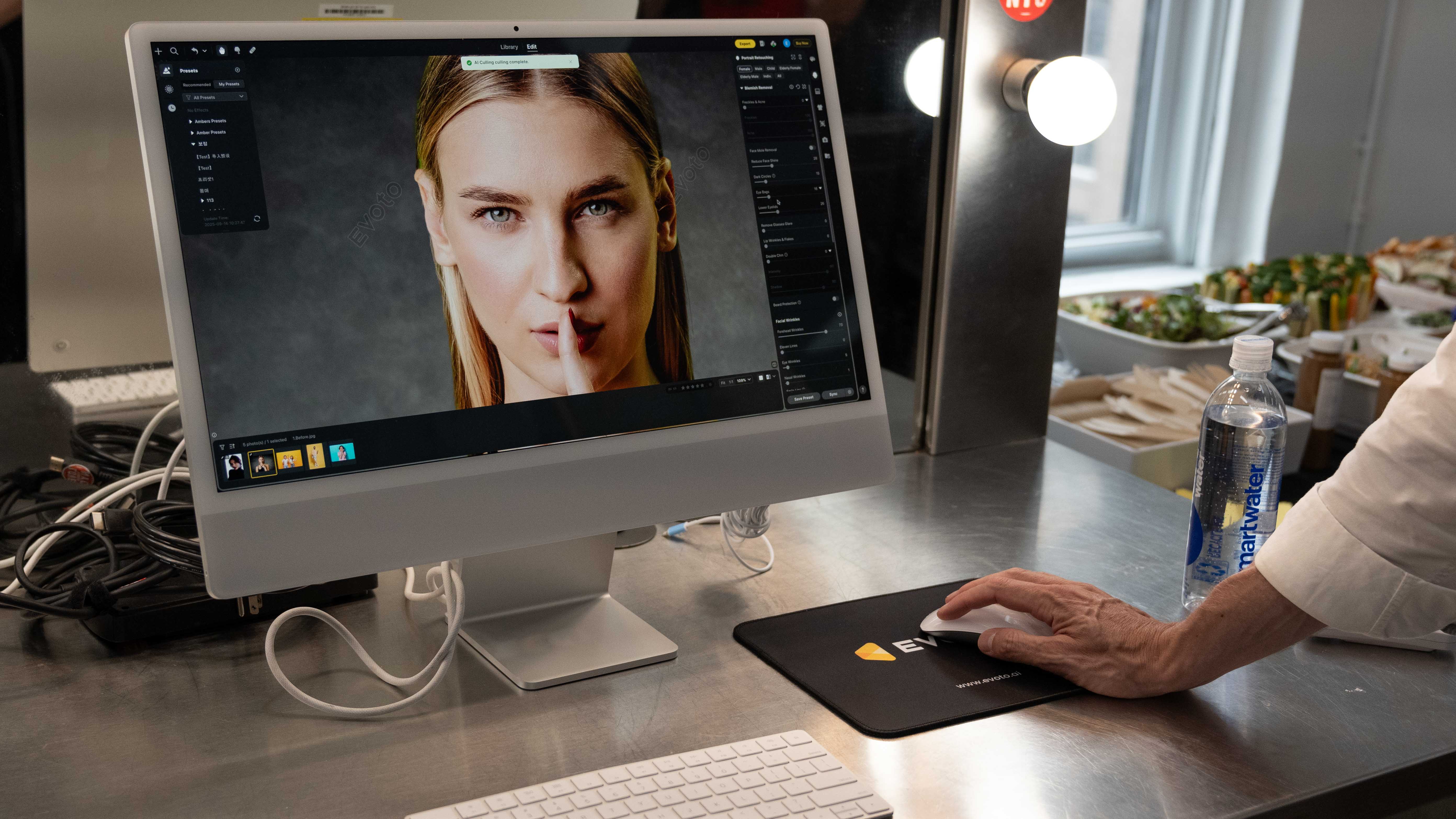 Evoto Desktop running on a Mac computer, with a hand in the frame using the mouse and a close-up image of a studio portrait on the screen 