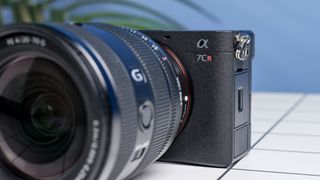 The Sony A7CR on a white table with a blue wall in the background