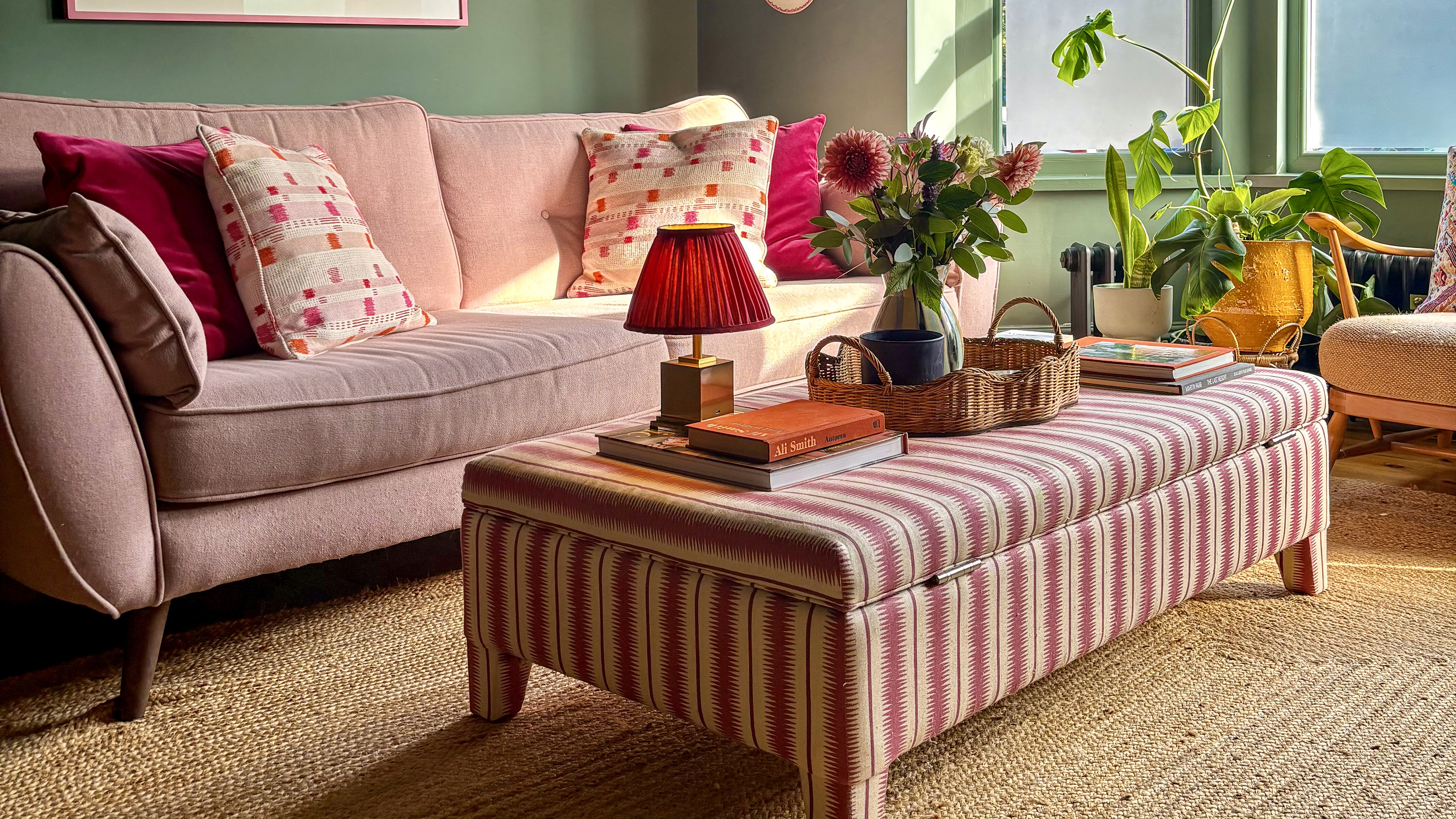 green living room with striped red ottoman in the middle