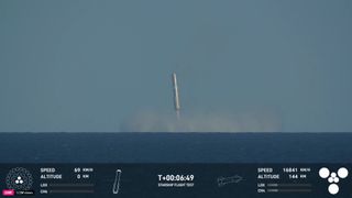 Starship Super Heavy Flight 6 booster hovers over the ocean during water landing and splashdown