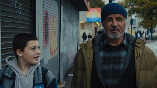 Sam, le personnage de Javon Walton, parle à M. Smith, le personnage de Sylvester Stallone, alors qu'ils marchent dans la rue dans le film Samaritan sur Prime Video.