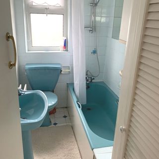 bathroom before picture with blue bath sink and toilet and light blue tiles