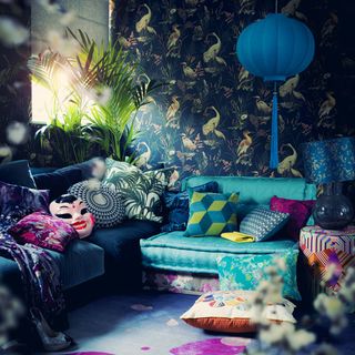 room with wallpaper with plant and pillows on couch