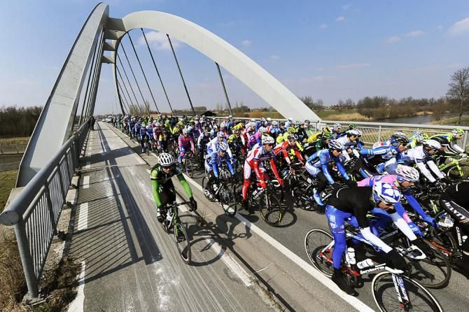 The peloton crosses a bridge