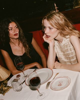 A photo of two models sporting a cranberry cream blush called "Pinot" from RMS Beauty's collaboration with Dôen.