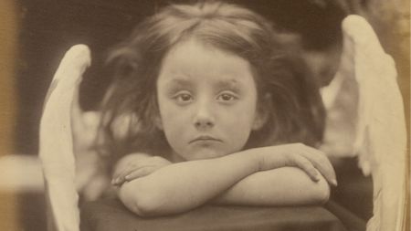 A black and white photo of a child with angel wings