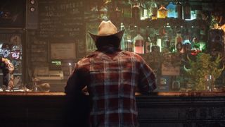 Wolverine sits in a bar with his back to the camera.  He wears a cowboy hat and a red flannel shirt.