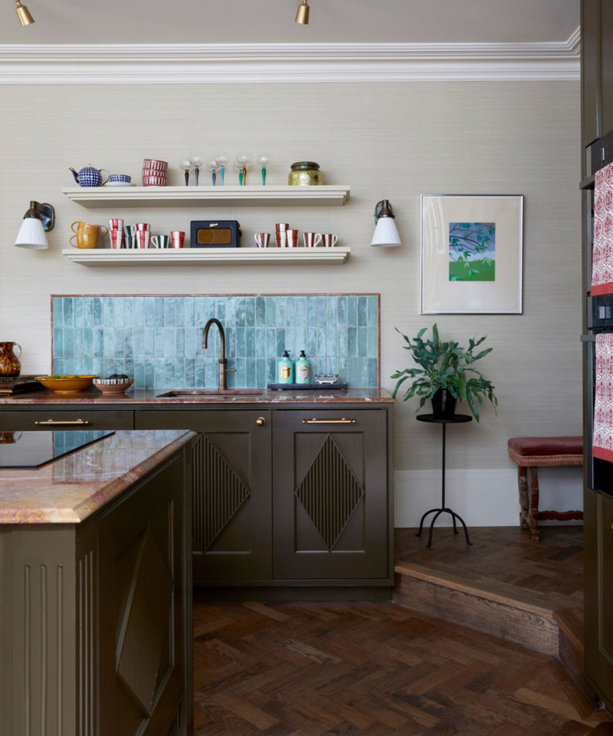 A small kitchen with warm white walls, a blue tile backsplash, and green cabinets with a textured diamond detail