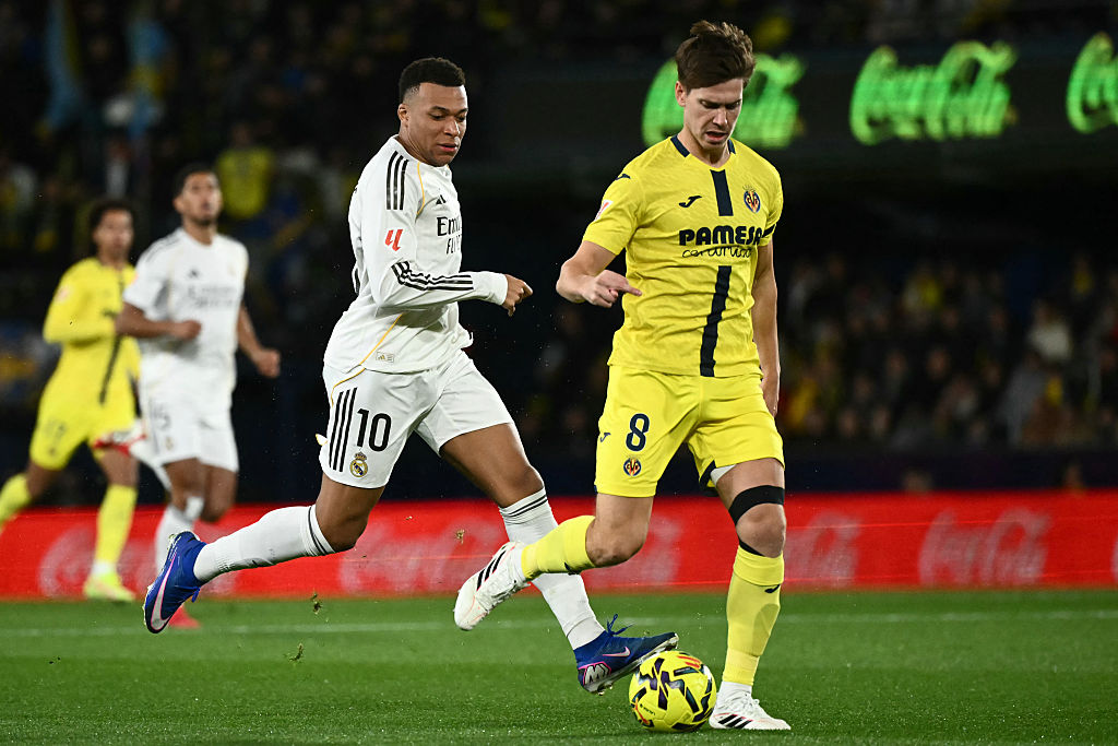 Real Madrid's French forward #10 Kylian Mbappe (L) challenges Villarreal's Argentine defender #08 Juan Foyth