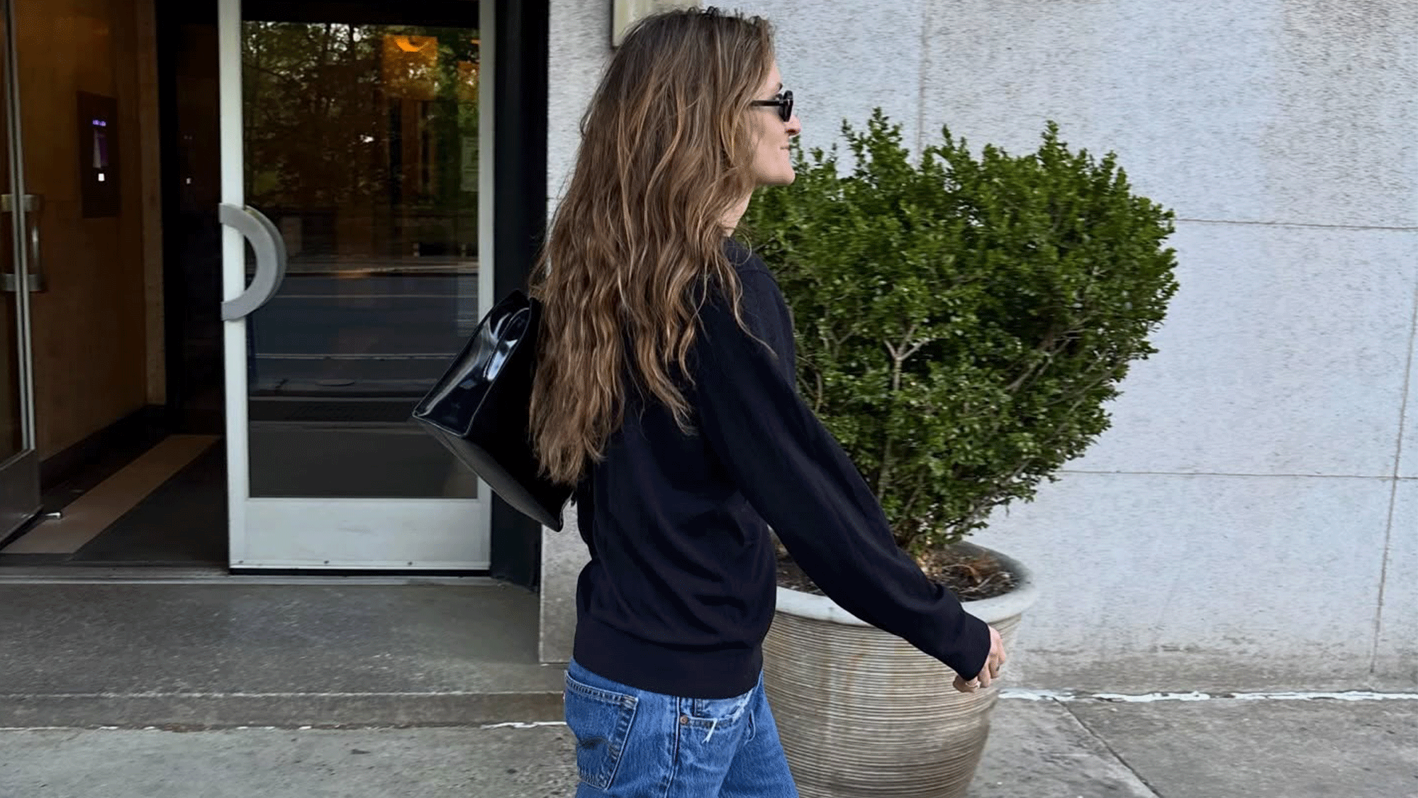 Woman wearing a black sweater and jeans.