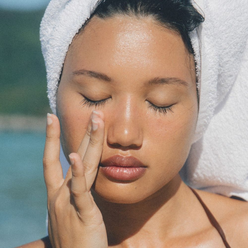 A woman applying skincare to her undereye area