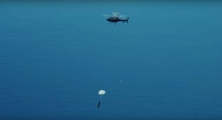 Rocket Lab used a helicopter to capture a falling Electron booster test article during a recovery test in early March 2020, as this screenshot from a company video shows.