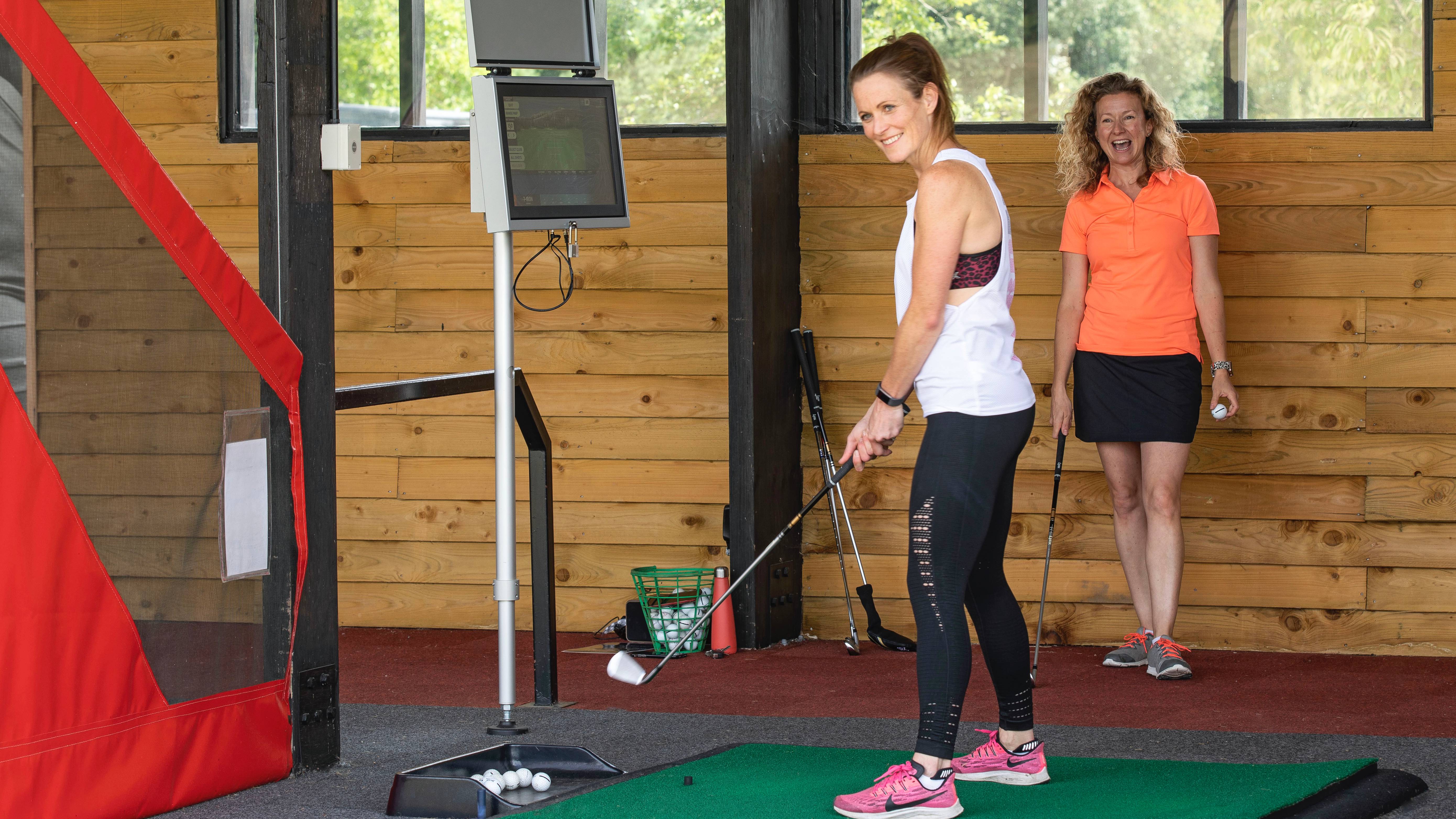 Katie Dawkins instructing a player at the golf range