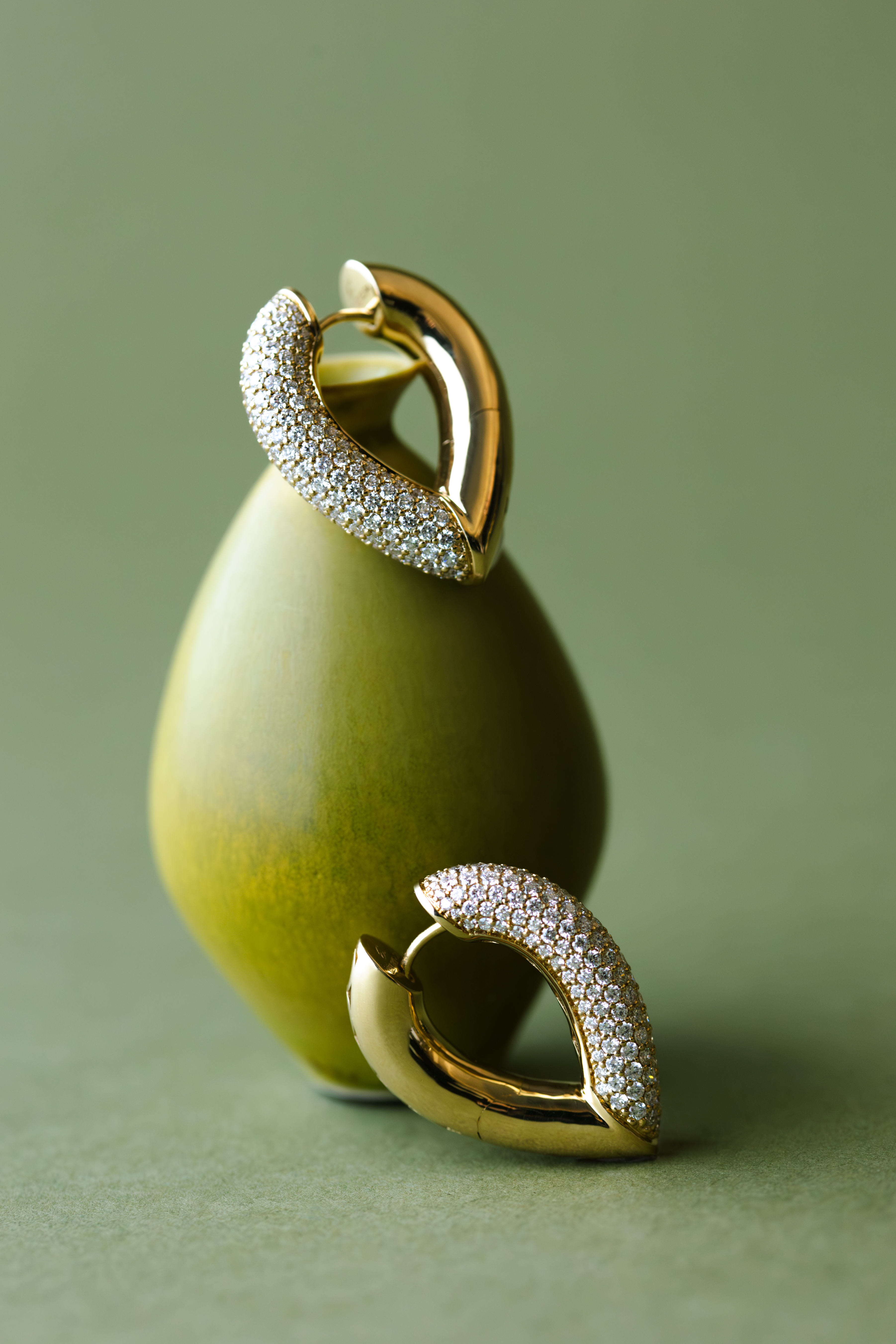 ceramics and jewellery against green and brown backgrounds