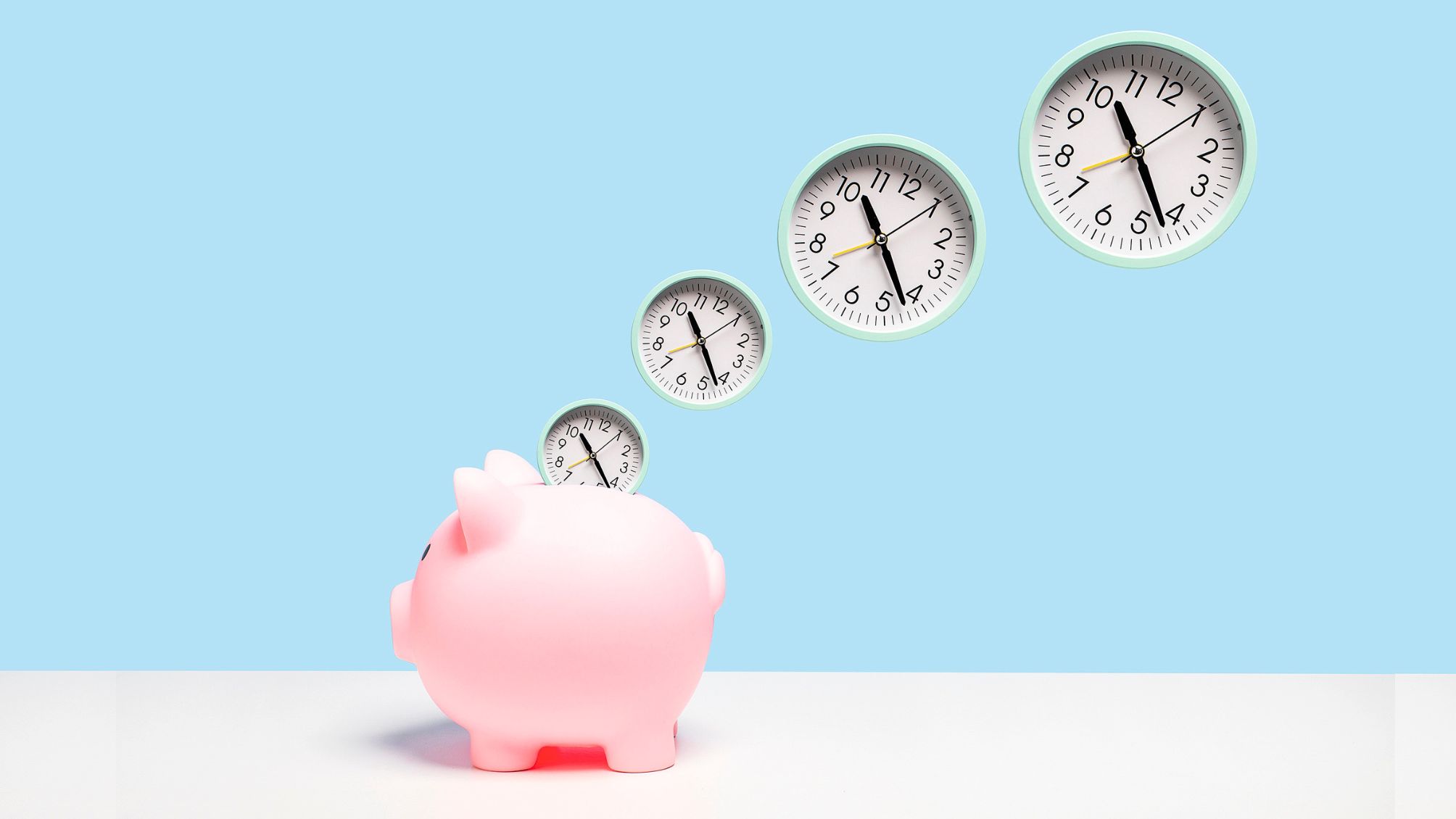 A piggy bank with four clocks above it 