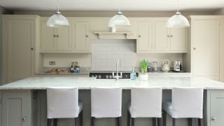 kitchen island with white composite worktop and white bar stools