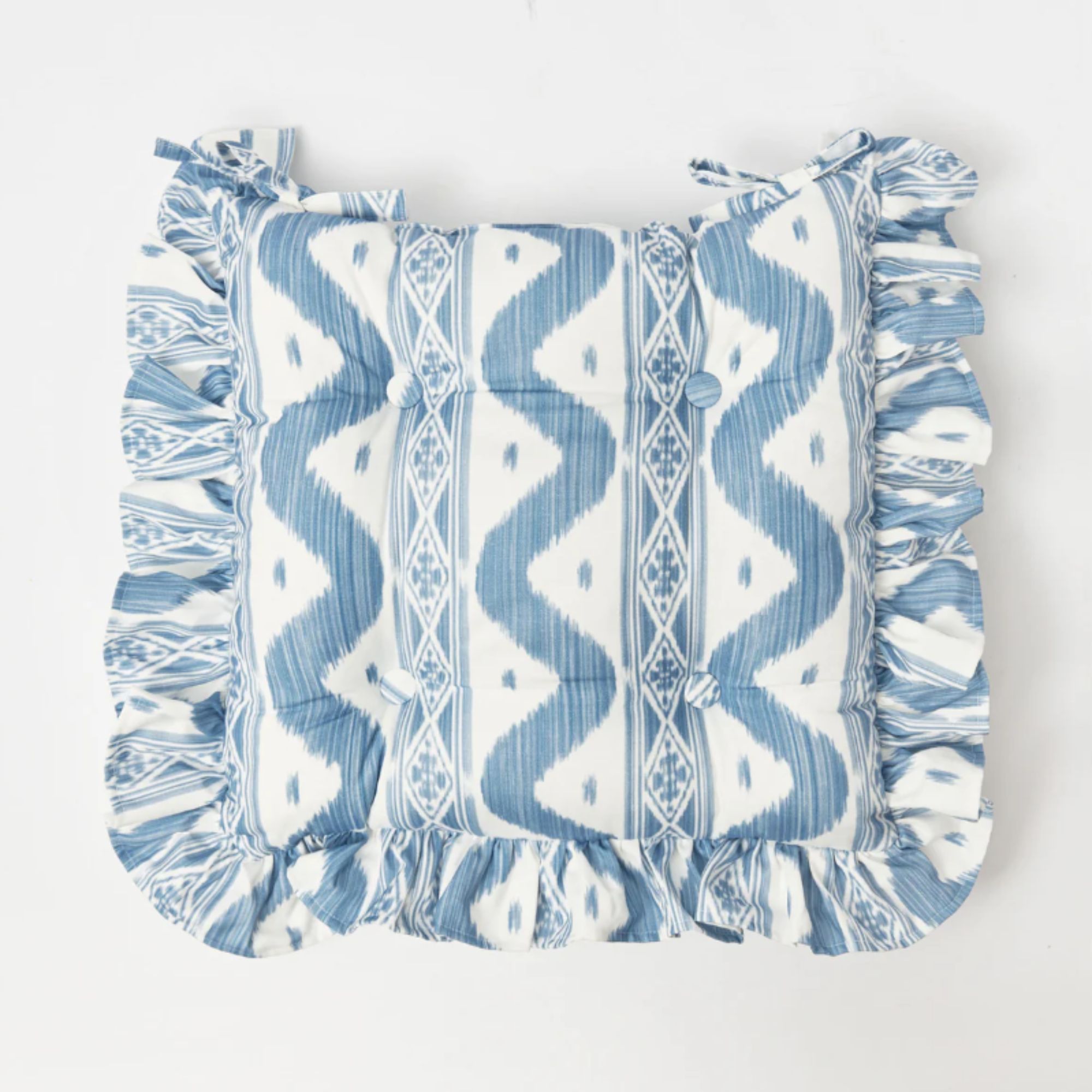 Blue and white ikat print seat cushion with frilled edges