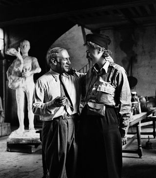 Pablo Picasso standing with his arm around Lee Miller