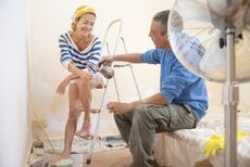 Couple taking a coffee break while renovating bedroom 