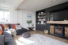 Hutchinson house: living room with black feature wall, large fireplace with woodburner and Scandi-style finishes