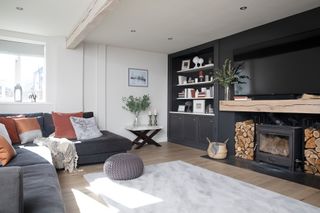 Hutchinson house: living room with black feature wall, large fireplace with woodburner and Scandi-style finishes