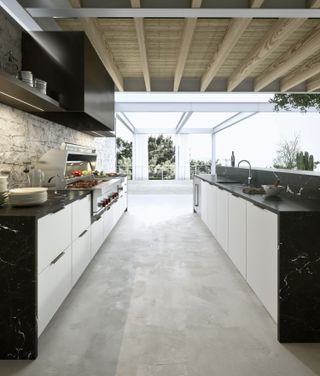 outdoor kitchen with concrete floor and monochrome kitchen units by hub kitchens