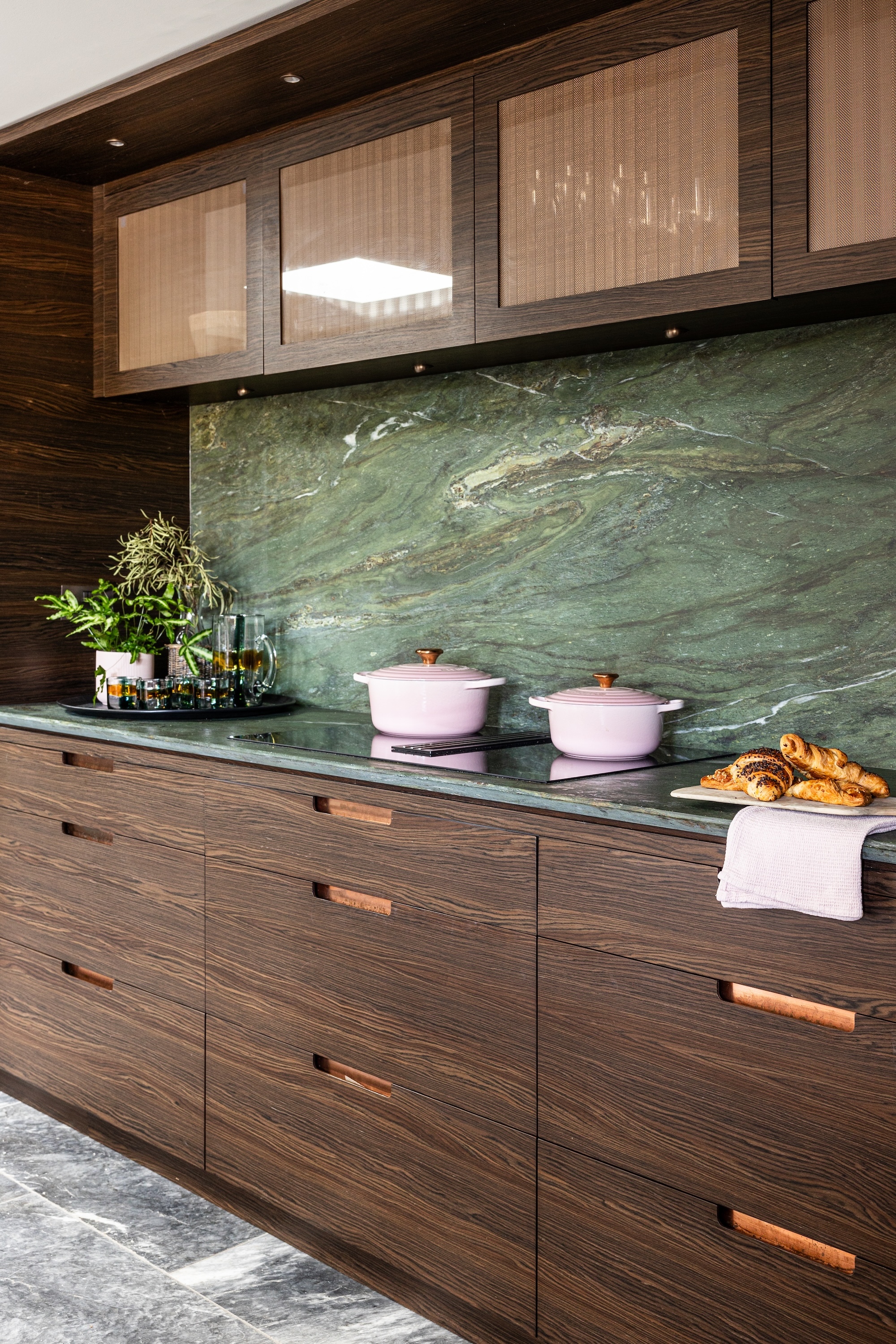 A dark wood kitchen with a green backsplash and countertop