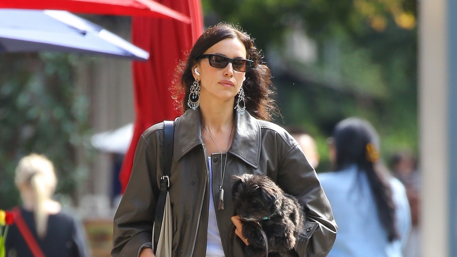 Irina Shayk wearing a brown leather bomber jacket, cream jeans, and cream fur ballet flats in NYC