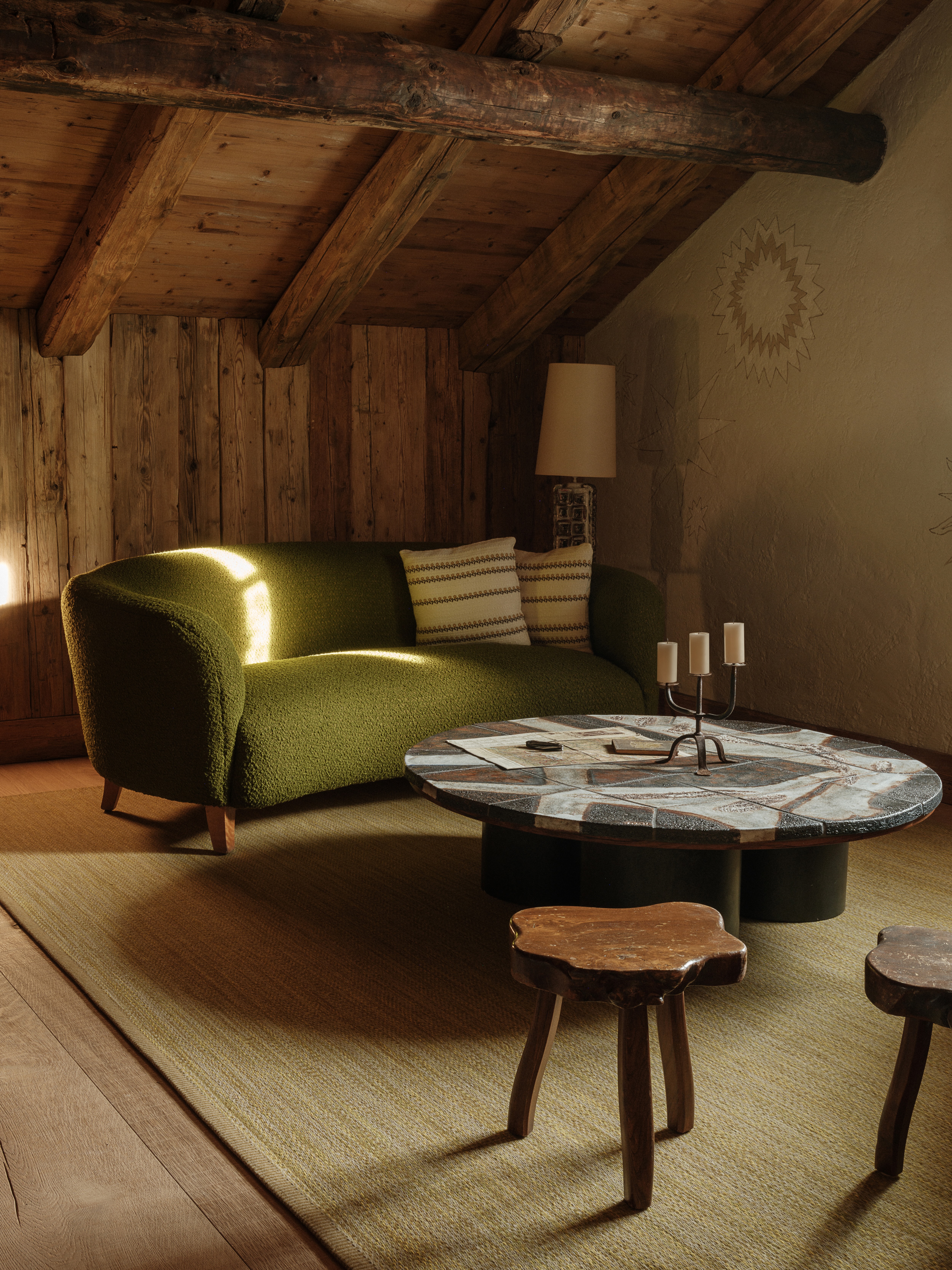 A green couch and wooden table inside a room at Chesa Marchetta