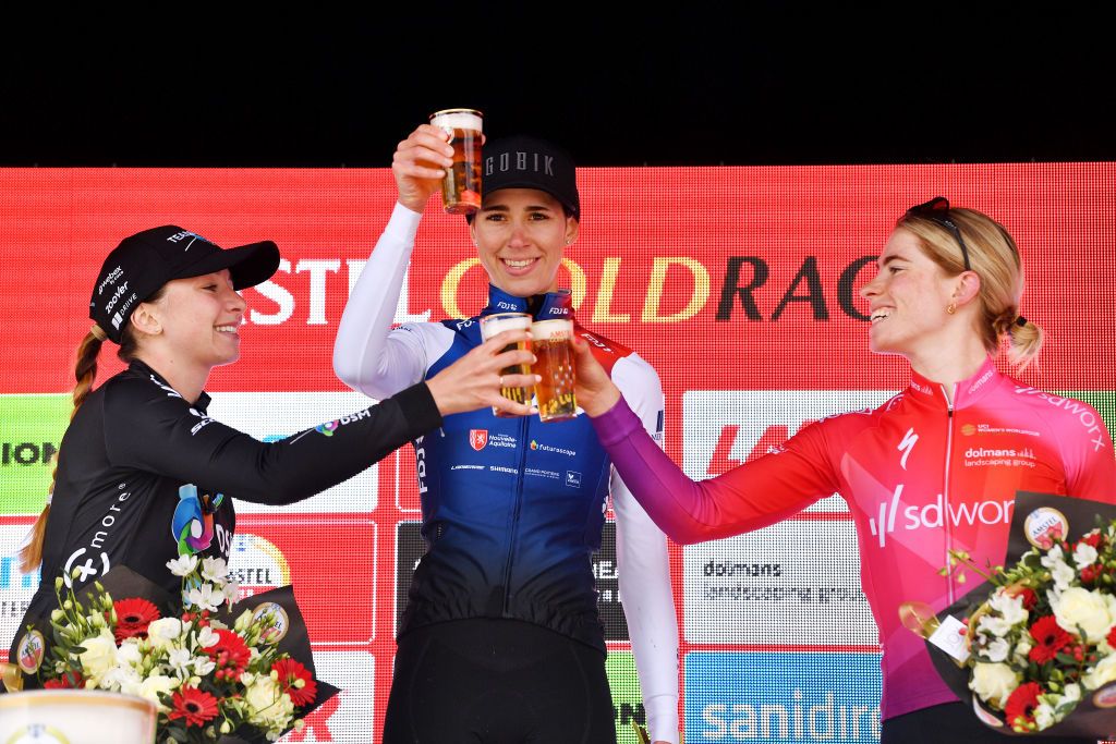 VALKENBURG NETHERLANDS APRIL 10 LR Liane Lippert of Germany and Team DSM on third place race winner Marta Cavalli of Italy and Team FDJ Nouvelle Aquitaine Futuroscope and Demi Vollering of Netherlands and Team SD Worx on second place pose and cheer with a beer on the podium during the podium ceremony after the 8th Amstel Gold Race Ladies Edition 2022 a 1285km one day race from Maastricht to Valkenburg UCIWWT AGR2022 on April 10 2022 in Valkenburg Netherlands Photo by Luc ClaessenGetty Images