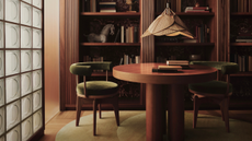 A contemporary space with a table and two chairs with bookshelfs behind and a glass brick wall with mood lighting and rug