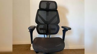 ThunderX3 chair set up in front of a white wall.