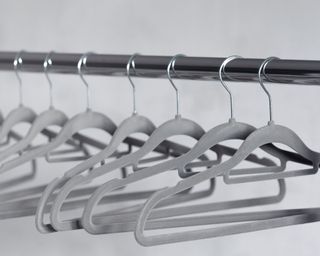 Grey velvet coat hangers on a rod