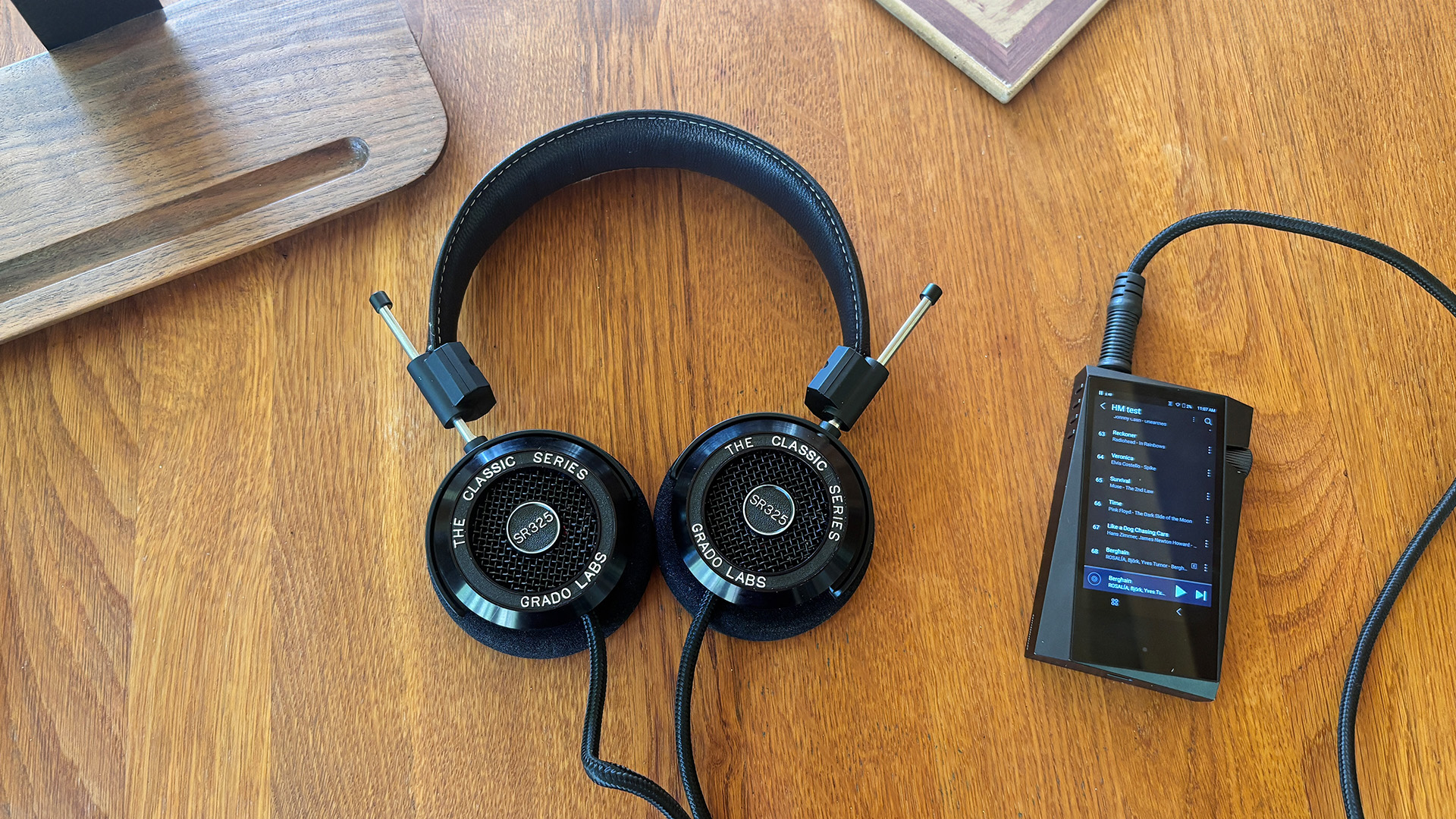 Grado SR325 Classic over-ear headphones on wooden desk plugged into Astell & Kern music player