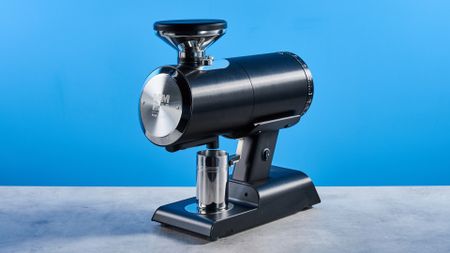 the mazzer philos coffee grinder in black and stainless steel photographed against a tom's guide blue background