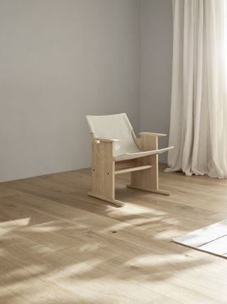 Chair with a natural linen fabric seat, hung hammock-like between two solid oak sides