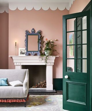 living room with pink walls and green molding and door