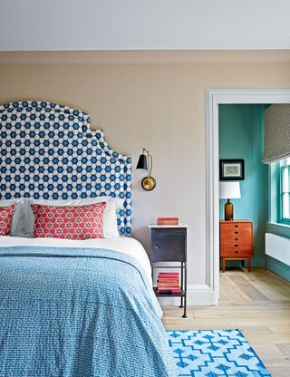 Neutral bedroom with beige walls and blue and white pattern headboard