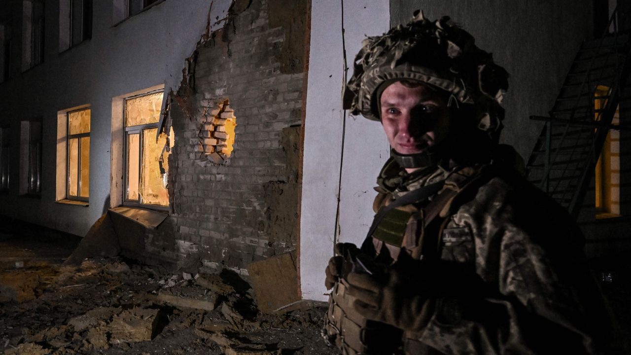 An Ukrainian soldier stands guard near debris after the reported shelling of a kindergarten in the settlement of Stanytsia Luhanska, Ukraine, on February 17, 2022.