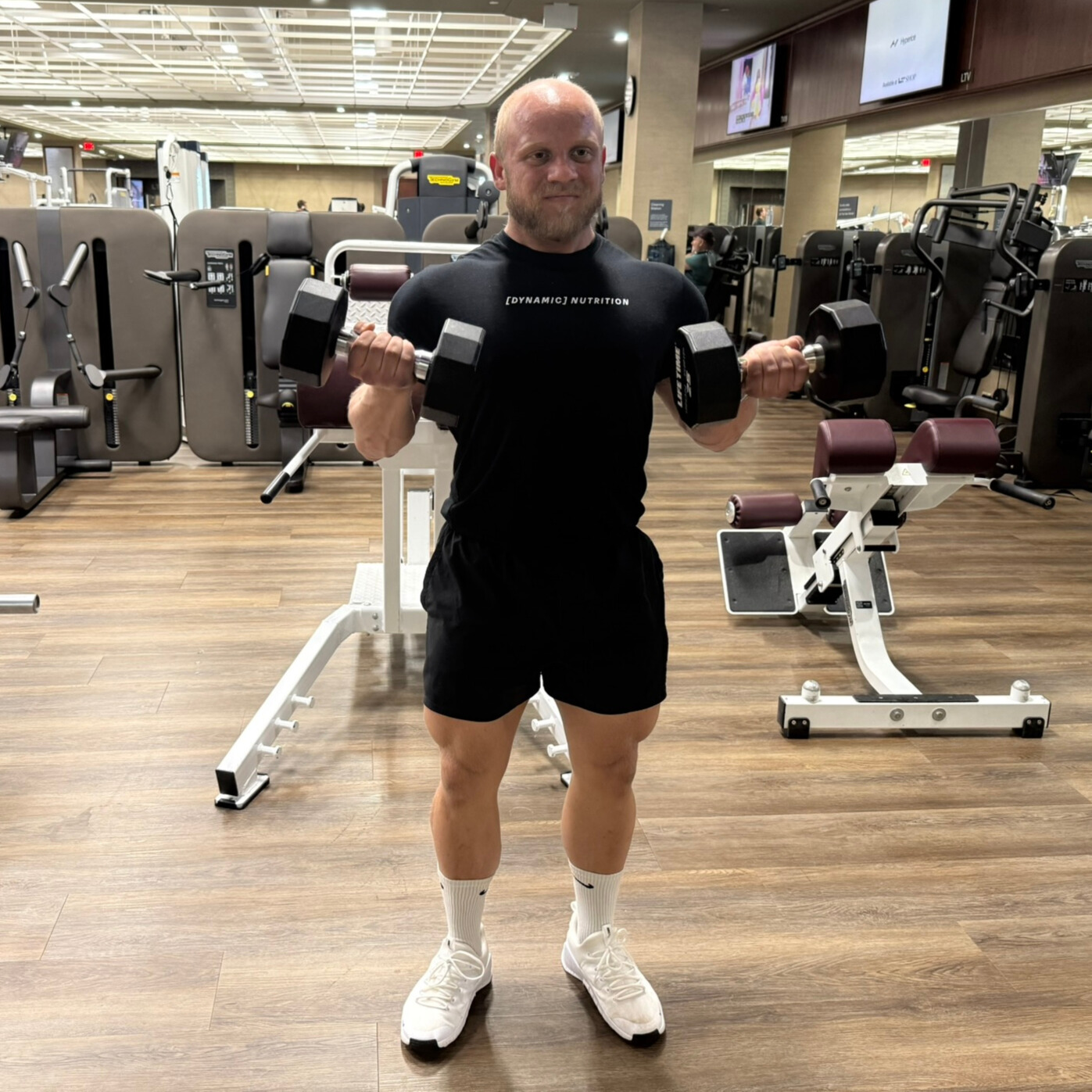 Man curling two dumbbells in gym