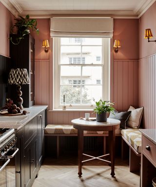 pink kitchen walls with a window banquette seat and cafe table