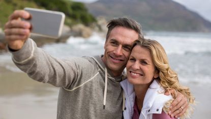 Mature couple taking a selfie at the beach