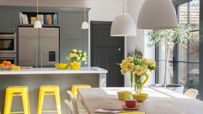 Navy kitchen utility room with Belfast sink, wicker basket storage and patterned tiled floor