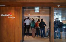 A group of travelers wait to get into a capital one airport lounge.